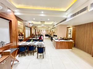 瓦拉纳西HOTEL VEDANGAM INN ! VARANASI - Forɘigner's Choice ! fully Air-Conditioned hotel with Parking availability, near Kashi Vishwanath Temple, and Ganga ghat 2的一间在房间内配有桌椅的餐厅