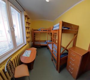 比亚韦斯托克波德拉谢青年旅馆的客房设有双层床、书桌和桌子。