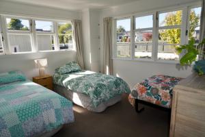 罗托鲁瓦Comfortable Home, Big Backyard的一间卧室设有两张床和两个窗户。