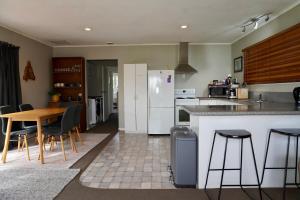 罗托鲁瓦Comfortable Home, Big Backyard的厨房配有桌椅和冰箱。