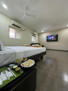钦奈Sangeetha Business Hotel的酒店客房设有一张大床和食品托盘