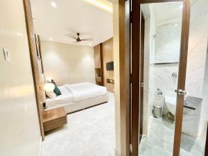 瓦拉纳西HOTEL VEDANGAM INN ! VARANASI - Forɘigner's Choice ! fully Air-Conditioned hotel with Parking availability, near Kashi Vishwanath Temple, and Ganga ghat 2的酒店客房配有一张床和淋浴