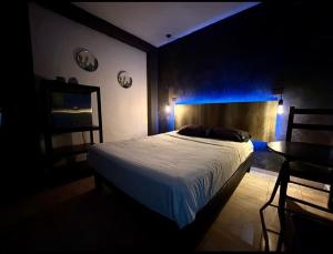 比亚埃尔莫萨Zyan Rooms的一间卧室配有一张床和一张蓝色光桌子