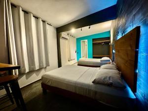 比亚埃尔莫萨Zyan Rooms的一间卧室设有两张床和蓝色的墙壁
