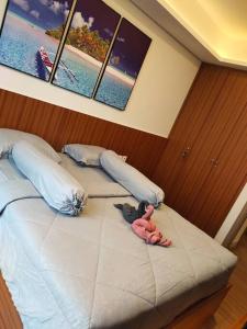 雅加达gold coast pik BEACH ROOM 1br netflix wifi sofa bed的卧室里床里有两个塞满了动物