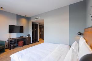 柏林TITANIC Comfort Kurfürstendamm的卧室配有白色的床和平面电视。