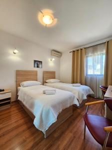 VrgoracHotel Prvan的酒店客房设有两张床和窗户。