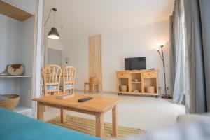 马翁皇家生活风尚公寓的客厅配有木桌和椅子