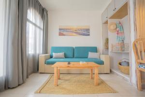 马翁皇家生活风尚公寓的客厅配有蓝色的沙发和桌子