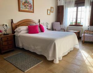 YusoPosada Las Torres的卧室配有一张带粉红色枕头的大床