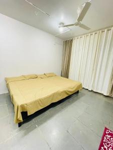 TuljapurTuljai Homestay的一间卧室配有一张黄色毯子床