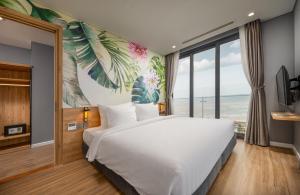 Nam KhêFlamingo Ibiza Hải Tiến的卧室设有一张白色大床和大窗户