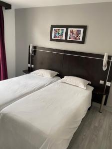 凡尔赛家园圣路易斯酒店的卧室内两张并排的床