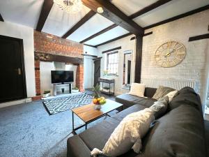 科尔切斯特Duchess House 1- Spacious & Modern 3BR GF的客厅配有沙发和墙上的时钟