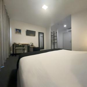 安曼Nomads Hotel的卧室配有白色的床和书桌