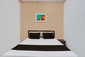 密拉特OYO Hotel Maharaja Palace的卧室配有带黑色枕头的白色床