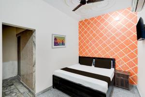 密拉特OYO Hotel Maharaja Palace的一间卧室配有一张带橙色瓷砖墙的床