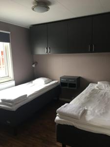 RosersbergLand-Inn Motel的配有黑色橱柜的客房内的两张床