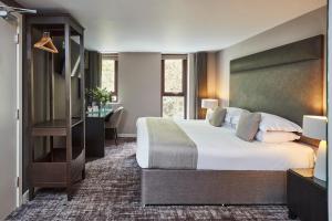 奥本The Ranald Hotel的酒店客房设有一张大床和一张书桌。
