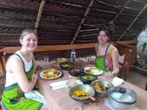 阿努拉德普勒Yaluwa Tourist Rest & cooking class的两个坐在餐桌边吃着食物的女人