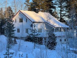 ValmenFamilievennlig bolig i Trysil的白色房子,有雪盖屋顶