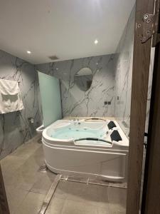 奈季兰SUN SET HOTEL فندق سن ست的带浴缸的浴室和大理石墙壁