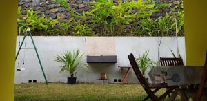 圣保罗Locations Alpinia Réunion的一个带墙壁、椅子和植物的院子
