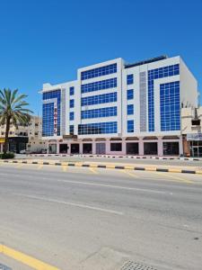 Al Fayşalīyahفندق روزميلون的道路一侧的大建筑