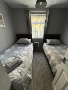 道利什Dawlish Warren Apartments的小型客房 - 带2张床和窗户