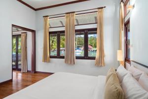 象岛Koh Chang Longstay Resort的卧室配有白色的床和窗户。