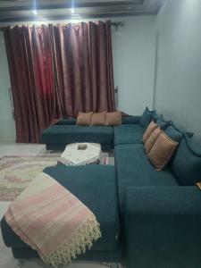 Al Mahallah Al Kubrasunwing pyramids view的客厅配有带枕头的蓝色沙发