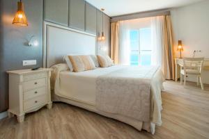 卡拉马奎达VIVA Cala Mesquida Resort & Spa的卧室配有一张白色的大床和一张桌子
