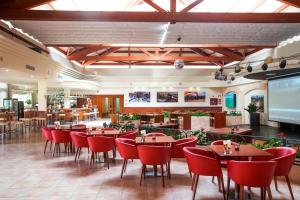 穆罗海滩VIVA Blue & Spa的一间餐厅,房间内设有红色的椅子和桌子