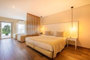塔维拉Hotel Rural Quinta do Marco - Nature & Dining的一间卧室设有两张床和大窗户