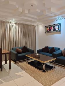 吉赞Aldar Hotel的客厅配有2张蓝色沙发和1张咖啡桌