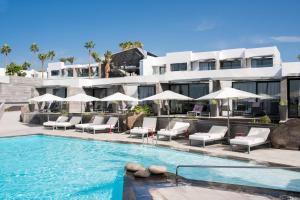 卡门港岛屿与海洋精品酒店的酒店设有带椅子和遮阳伞的游泳池