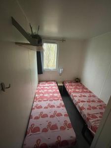 劳雷尔苏格Nette 4-persoons chalet aan het Lauwersmeer的小型客房 - 带2张床和窗户