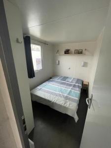 劳雷尔苏格Nette 4-persoons chalet aan het Lauwersmeer的一间小卧室,配有床和窗户