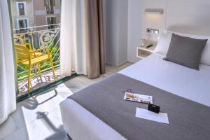 巴塞罗那SERHS Carlit Boutique Hotel的酒店客房设有一张床和一个阳台。