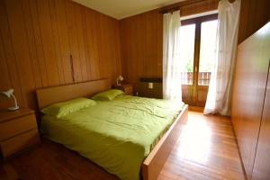 摩德纳迪-坎皮格里奥Casa Faè Dolomiti的一间卧室设有一张床和一个大窗户