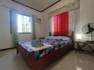 波尔多·格尼拉阿尼努安河滨住宿加早餐旅馆的一间卧室配有一张带红色窗帘的床