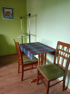 哈伊努夫卡Kornatka Hajnówka Pokoje Puszcza Białowieska的一张桌子和两把椅子以及一张桌子和一盏灯