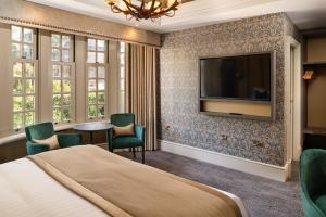 艾尔Brig o' Doon House Hotel的配有一张床和一台平面电视的酒店客房