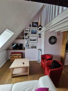 翁弗勒尔Phare des Impressionnistes的客厅配有红色的沙发和桌子