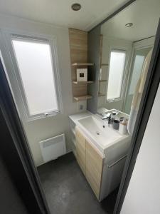 劳雷尔苏格Nette 4-persoons chalet aan het Lauwersmeer的一间带白色水槽和窗户的浴室