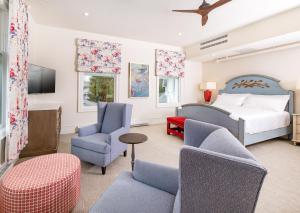 麦基诺岛The Inn at Stonecliffe的一间卧室配有一张床铺和椅子以及一台电视。