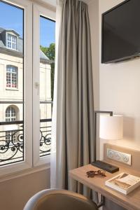 巴黎提姆酒店的客房设有书桌和带桌椅的窗户。