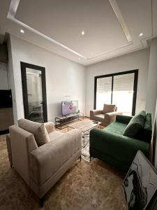 突尼斯joli appartement a jardin de Carthage的客厅配有两张沙发和一台电视机