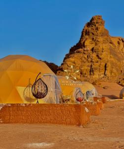 瓦迪拉姆RUM SUNRlSE LUXURY CAMP的沙漠中一群圆顶,有岩石