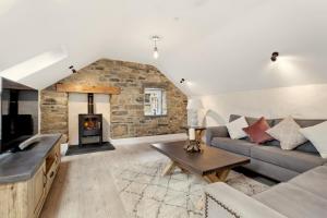 圣大卫Awel y Môr - 3 Bedroom Cottage - Whitesands的带沙发和壁炉的客厅